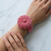 Dusty Rose Corduroy Pin Cushion on a person's wrist against a marble background