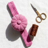 Peony Pink Corduroy Pin Cushion with gold scissors and thread on white background