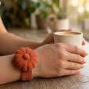Person holding a mug with a Terracotta Corduroy Pin Cushion bracelet on a wooden surface