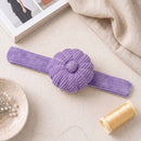 Wild Lilac Corduroy Pin Cushion on a neutral surface with a spool of thread and fabric